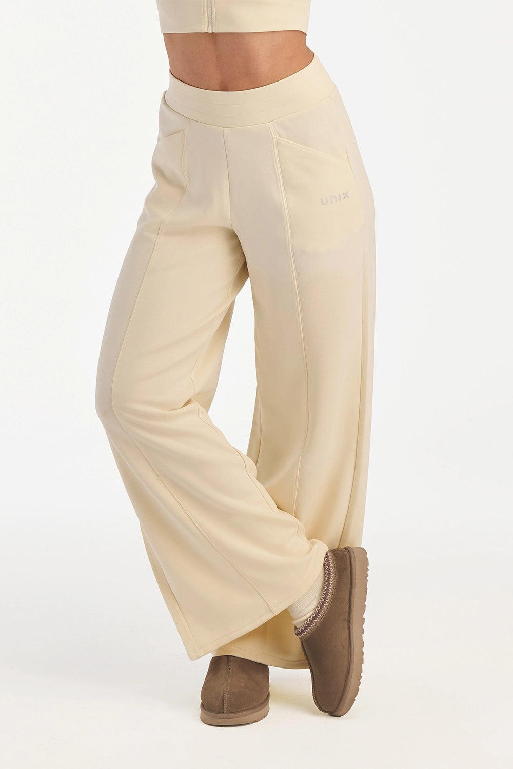 Cream wide leg pants women front view minimal activewear - UNIX | بنطلون وايد ليج كريمي نسائي من الأمام بتصميم بسيط للرياضة والحياة اليومية - UNIX
