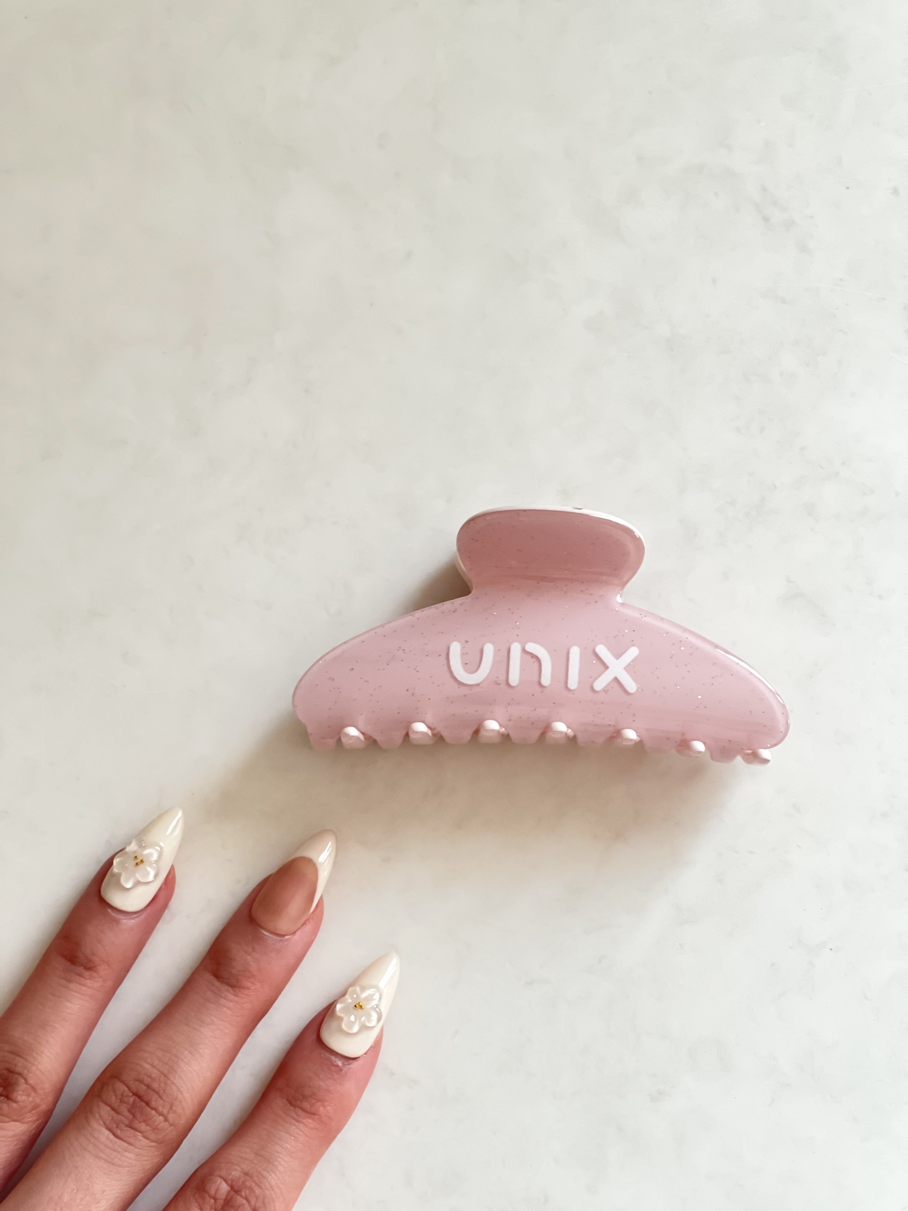 Powder pink hair clip in hand minimal everyday design - UNIX | مشبك شعر وردي بتصميم بسيط للاستخدام اليومي - UNIX